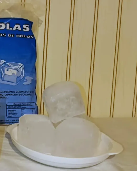 Cubos grandes de hielo en un plato, junto a una bolsa Yancolas